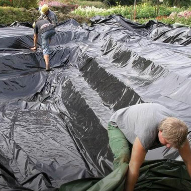 Männer bauen einen Teich