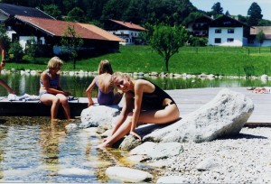 Frauen sitzen am Wasser des Naturpools