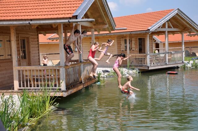 Kinder springen in den Schwimmteich des Wandergaul Chiemgau