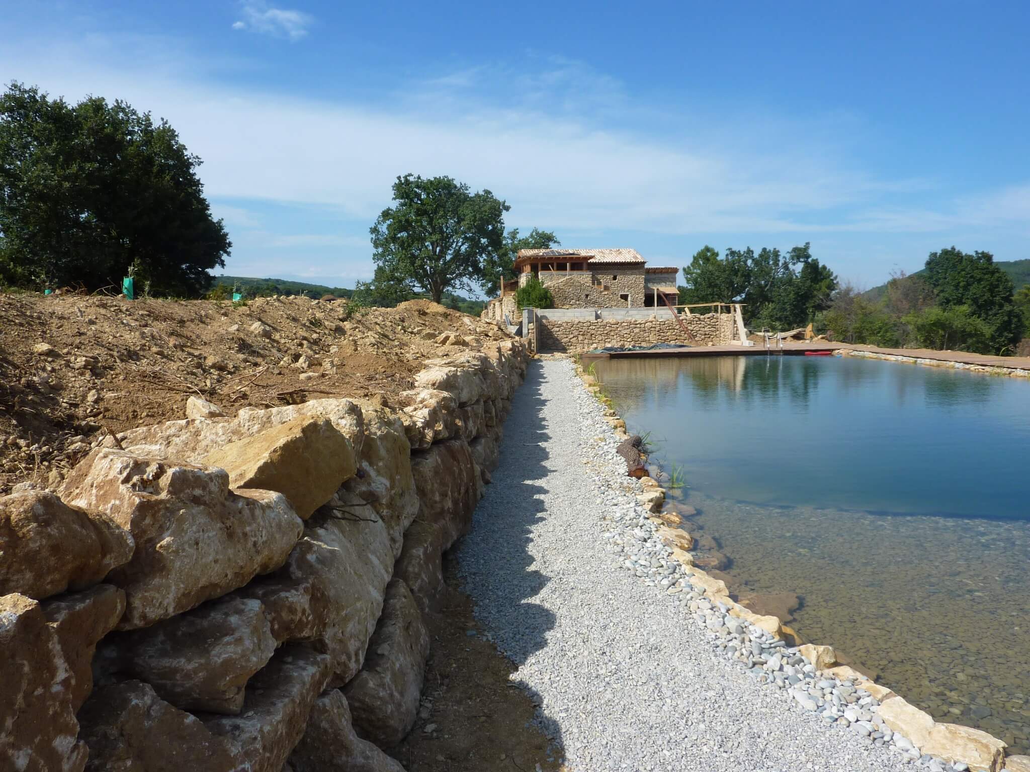 Schwimmteich in Frankreich mit Findlingen im Wasser